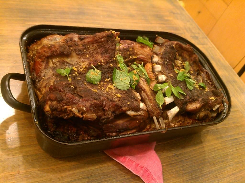 A rack of lamb in the oven with mint