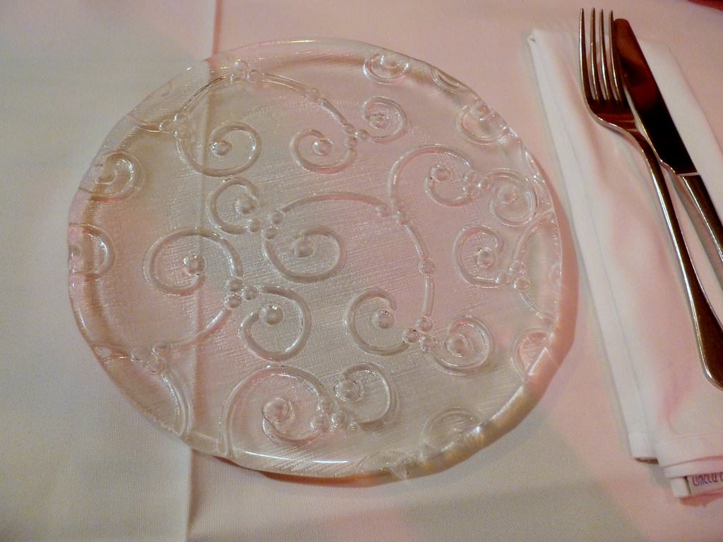 These plates are beautiful and the tablecloth is clean and white.