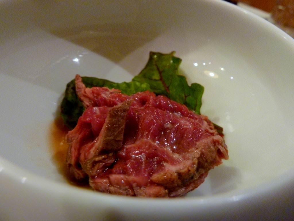 Marinated Tataki Beef with some green leaves.