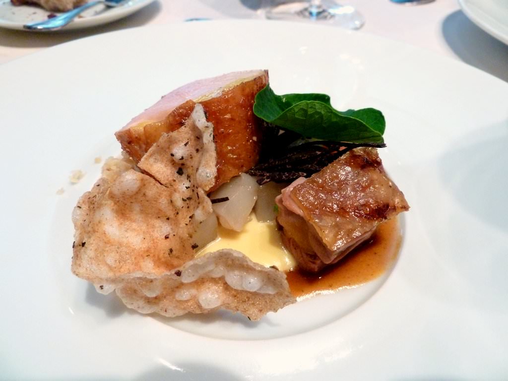 Hay smoked breast and thigh of "Poularde de Bresse" with Jerusalem Artichoke, Parmesan and walnuts "sand", Parmesan cheese and black truffles sauce, crispy tapioca, a Capucine leaf and Za'atar.