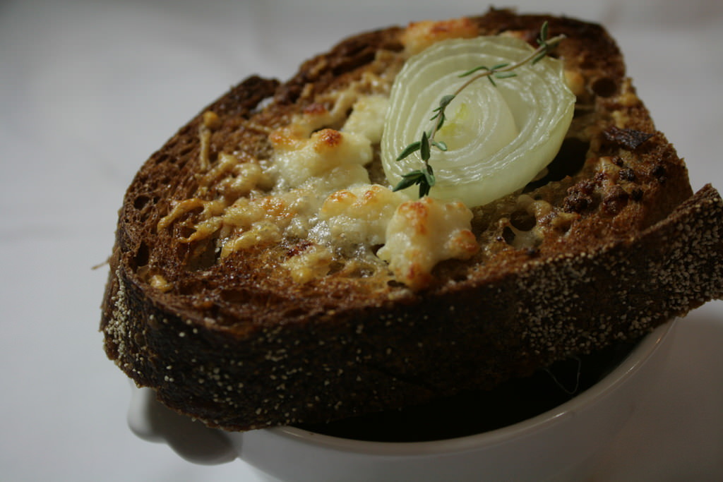 What's a winter without a soup? Dual layer onion soup: classic veal stock and white wine onion soup on top of caramelized onion cream. Served with parmesan foam and grilled country bread toast with parmesan, a slice of onion and thyme.